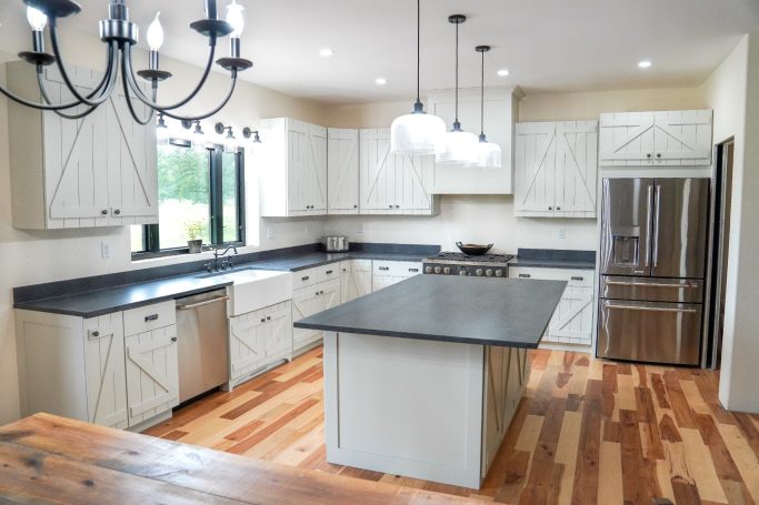 Full kitchen image of Amish designed custom cabinets with a beautiful view outside the kitchen window.